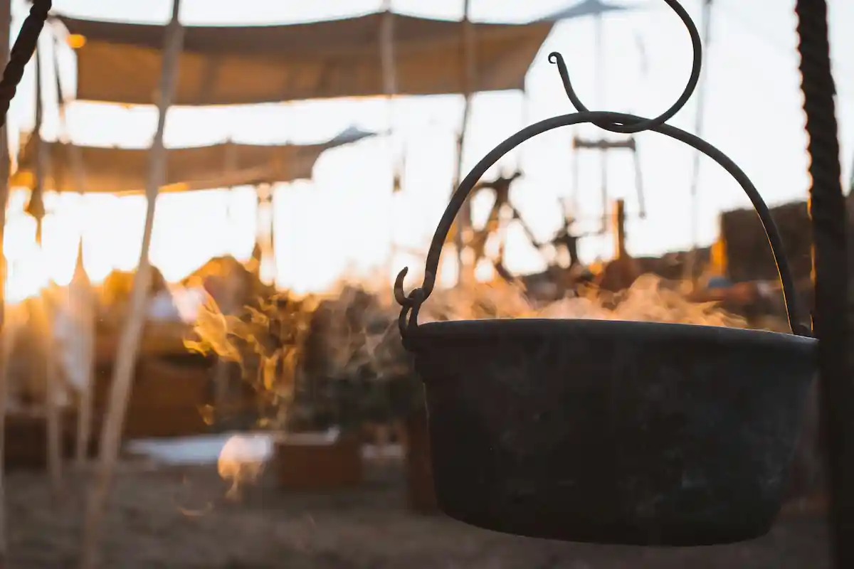 A rustic pot of soup with steam coming out